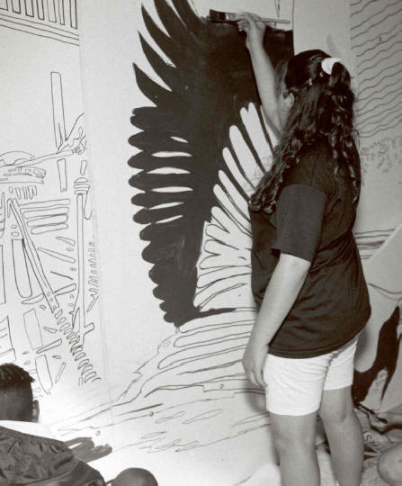 A youth paints one of the six historic murals for Up Bound project.